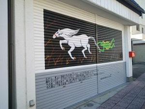 走る馬のしっぽを持つ河童が描かれたシャッターの写真
