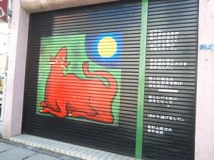 月を見る赤い牛が描かれたシャッターの写真