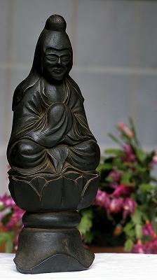 蓮の花の上に座っており、優しい表情の木彫像の木喰仏(岩船地蔵像)の写真