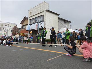 綱引きをする参加者とピストルを持っている市長の写真