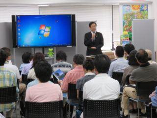 移住セミナー参加者が席に着いており、市長が参加者の前でマイクを持って話をしている様子の写真