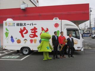 移動スーパーやまとの車両の前に並ぶ、市長、ニーラ、関係者の写真