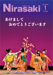 舞台の上で5人の着物を着た女の子たちが円になって日本舞踊を踊っていて、手に持った花の飾りを中央に差し出している様子が写っている広報にらさき1月号表紙