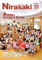 室内の木製の遊具の上で万歳をしている沢山の子供たちと保護者が写った写真が載っている広報にらさき10月号表紙の写真
