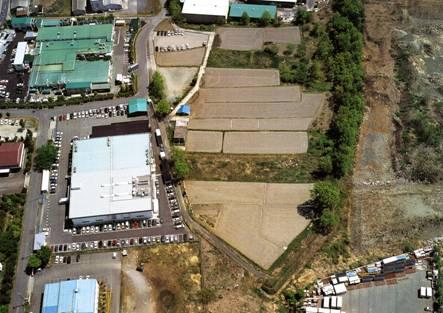 上空から写しており、工場のような白い建物の横に御勅使川旧堤防（将棋頭）が写っている写真