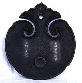 黒い銅で出来ており、円形で上部が雲の形で左右型取られている雲版の写真