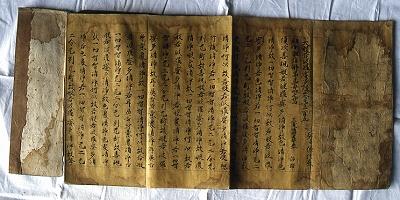 茶色い紙に墨で大般若経が書かれている大変古い時代の物とわかる、一条六郎信長寄進の大般若経の写真