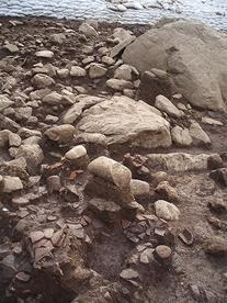 巨大な岩や石、土器のような物が沢山地面に埋まっている様子の写真