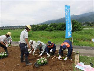 川公園周辺の花壇の草が綺麗に整備され、ボランティア活動に参加されている方々が、花を植栽している様子の写真