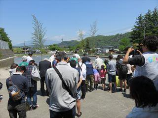 韮崎高等学校東都同窓会で、晴天の下、参加者が神事に参加している様子を後方から写している様子の写真