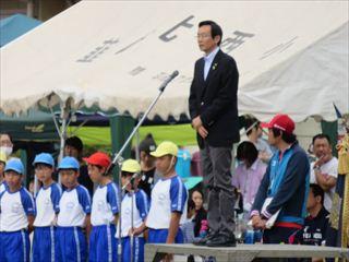 小学校大運動会で、指揮台に立ち挨拶をする市長の写真