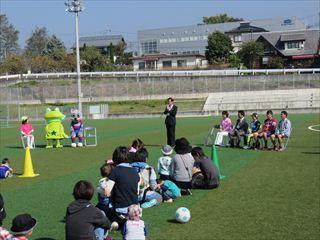 サッカーフェスで、参加した親子の前で話をする市長の写真