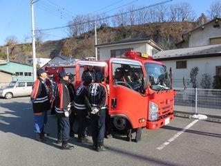 最新鋭の救助資機材搭載型消防ポンプ自動車を見ている消防団員の写真