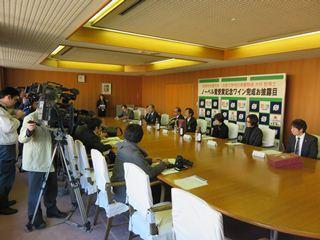 大村智名誉市民ノーベル賞受賞記念ワインプレスリリースで、カメラマンや記者の前で話をする、市長や関係者の写真