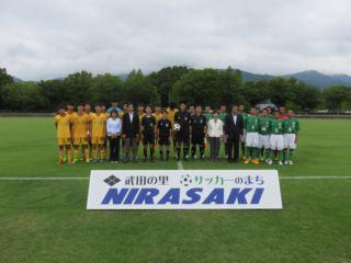 緑や黄色のサッカーのユニフォームを着た高校生たちが並んでいる写真