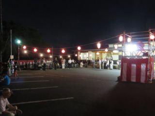 提灯と櫓が設置されている祭り会場の写真