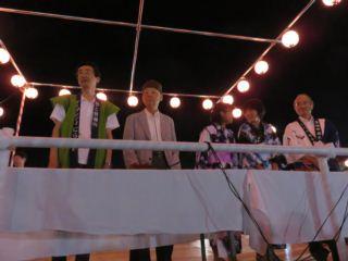 櫓の上に並ぶ、法被を着た市長と大村 智さん、関係者の写真