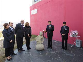 大村美術館アルメニア彫刻寄贈にて、彫刻作品の前に立って話をする市長の写真