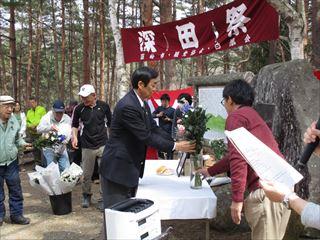 深田祭で、市長が花瓶に入った花を飾っている写真