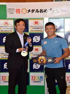 ベルトを持つ文田健一郎選手と、金メダルをもつ市長が並んでいる写真