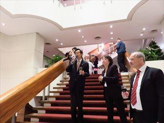 日本チェコ友好協会クリスマスレセプションで、階段にたちマイクをもって話をする市長の写真