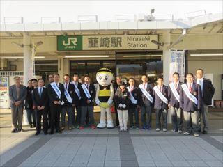 韮崎駅の前で韮崎高校野球部の皆さん、関係者、着ぐるみが並ぶ集合写真