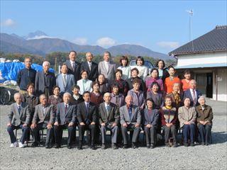 岩下地区敬老会の出席者と市長が青空の下、並んで写っている集合写真