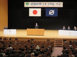 東京エレクトロン韮崎文化ホールの会場で、[武田の里ライフカレッジ」と書かれている横断幕の前で、市長が話をしている閉講式の様子の写真