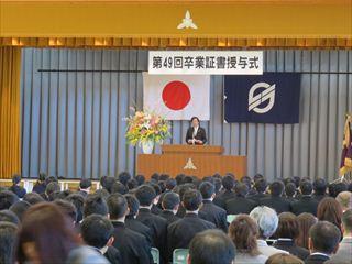 韮崎東・西中学校で卒業式で、「第41回卒業証書授与式」と書かれている横断幕の前で市長が卒業生の前で話をしている様子の写真