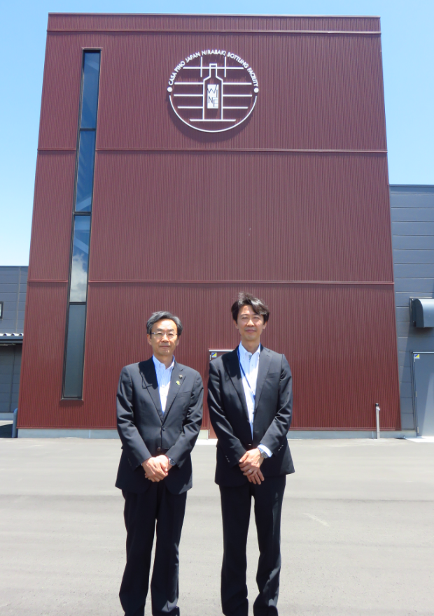 カサ・ピノ・ジャパン株式会社の建物前に立つ、市長と男性の写真