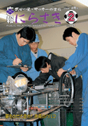 青い作業服と黒い作業服を着た男性4人が車輪の付いた装置をいじっている写真が載っている広報にらさき2月号表紙