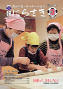 2人の年配の女性と綿棒で生地を巻いている男の子が料理をしている写真が載っている広報にらさき3月号表紙