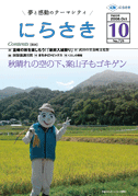 黄色に色付いた稲穂が広がる田んぼの前に1体のベストを着、帽子を被った笑顔のかかしが立っている写真の広報にらさき10月号表紙