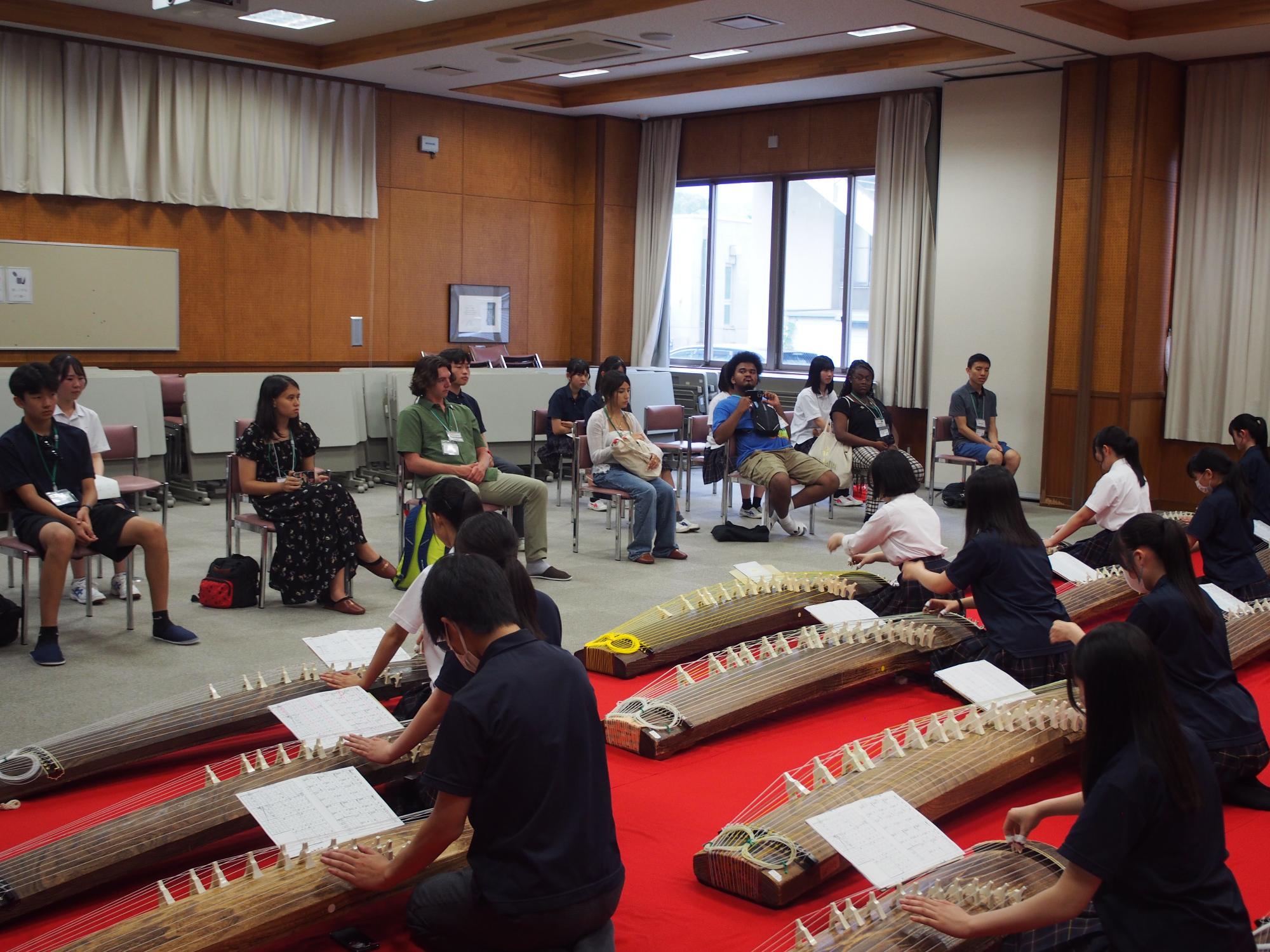 フェアフィールド市の学生が韮崎高校で琴部の演奏を聴いている様子