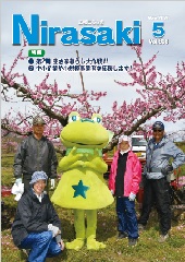 ニーラと農家の方たちが桃の木の前で笑顔で写っている広報にらさき5月号の表紙