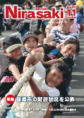 前には子供たち、後ろには大人たちが並んで綱引きの綱を引っ張っている姿を映している広報にらさき11月号表紙