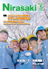 桜の木の下で水色の帽子をかぶり、水色の服を着た保育園児5人がピースをしている姿が写っている広報にらさき5月号表紙