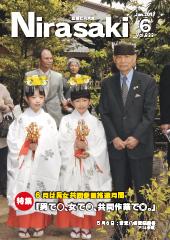 白い着物を着て、手に金色の神具を持った女の子2人の隣に大村智博士が並んでいる姿が写っている広報にらさき6月号表紙