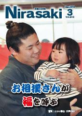 頭にちょんまげを結ったお相撲さんが小さい女の子を抱きかかえて微笑んでいる姿が写っている広報にらさき3月号表紙