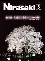 辺りは真っ暗で一本の大きな桜の木がライトアップされていて、周りに人が集まっている様子が写っている広報にらさき5月号表紙