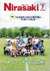 奥には山と木があり、手前にある芝生の上にたくさんの親子が並んでいる姿が写っている広報にらさき7月号表紙