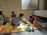 託児所の職員が、おもちゃを使って子供と遊んでいる写真